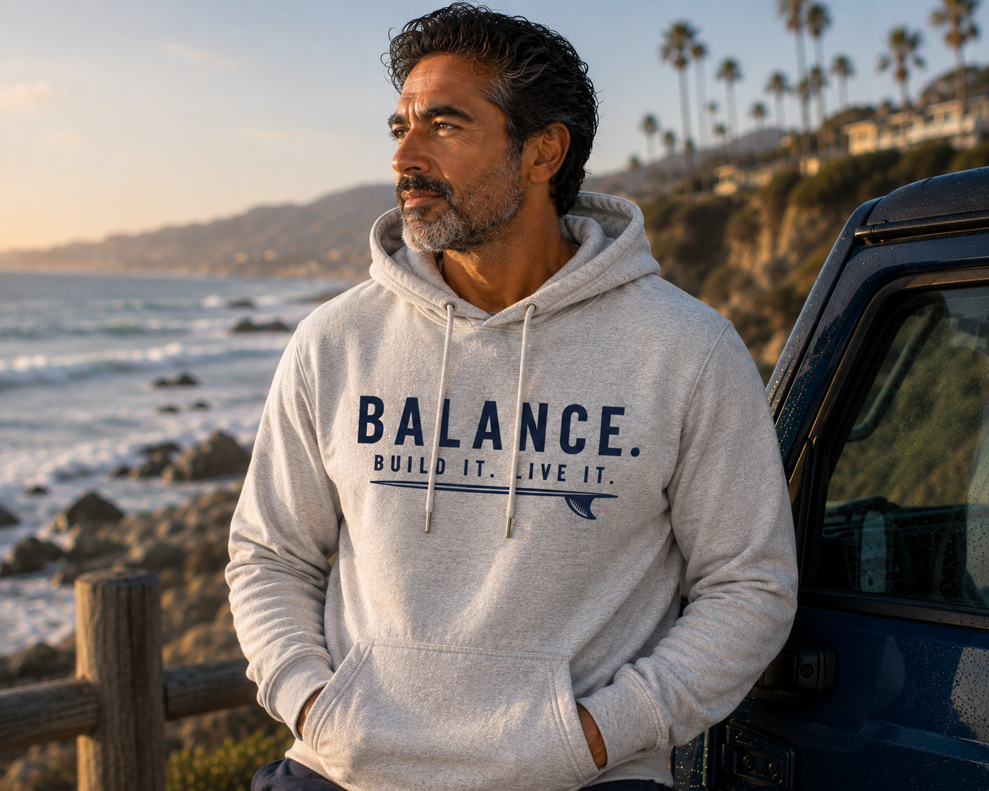 Man wearing the Balance Build It Live It hoodie beside the coastal cliffs
